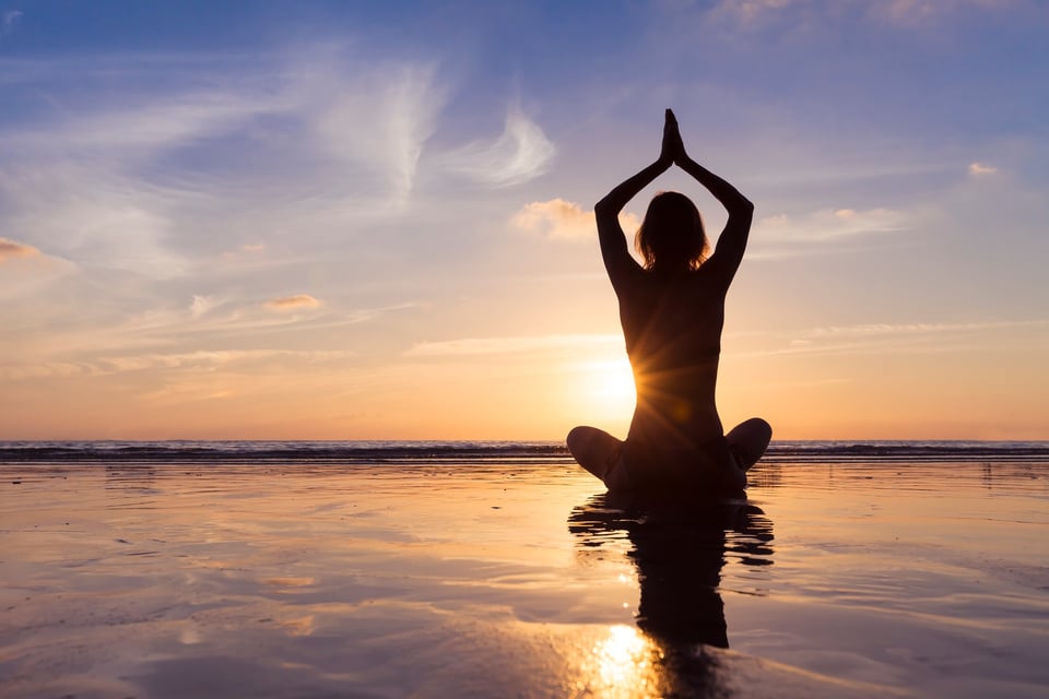 Young woman practicing yoga for meditation and well-being, beach